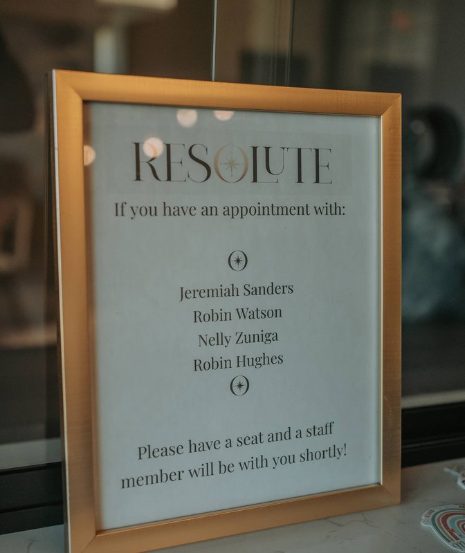 A younger woman in a chair being addressed by an older professional.